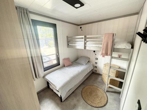 ein kleines Schlafzimmer mit einem Etagenbett und einem Fenster in der Unterkunft Chalet standing, 6 couchages, piscine chauffée, terrasse privée, proche plage et commerces - FR-1-361-520 in Jullouville-les-Pins