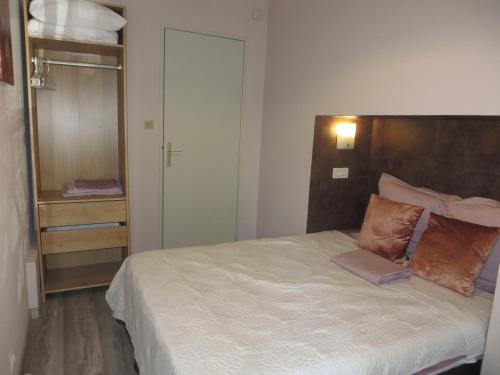 Schlafzimmer mit einem großen Bett mit einem Kopfteil aus Holz in der Unterkunft Appartement Porte Évêque in Avignon