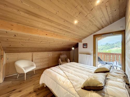 une chambre avec un grand lit et une grande fenêtre dans l'établissement Appartement neuf avec vue Mont Blanc, parking et wifi à Combloux - FR-1-560-113, à Combloux