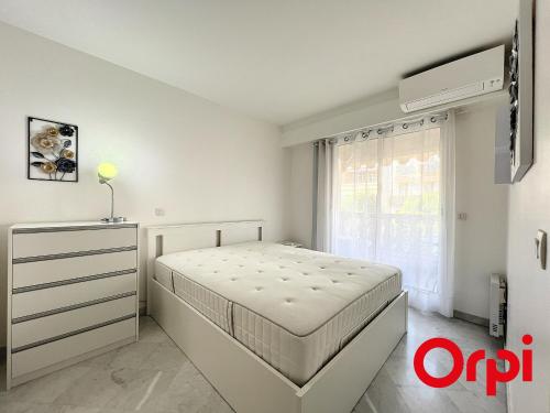 une chambre blanche avec un lit et une fenêtre dans l'établissement Appartement Central proche Plages avec Piscine, Sauna, Parking et Climatisation - FR-1-647-23, à Menton