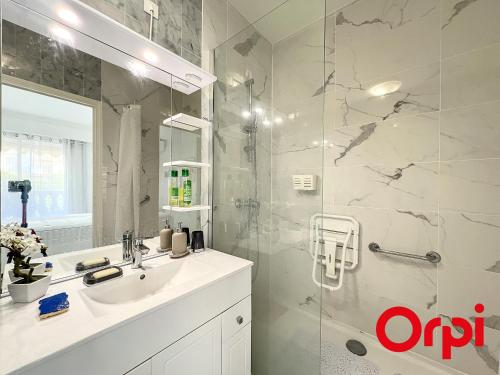 une salle de bain avec un lavabo et une douche dans l'établissement Appartement Central proche Plages avec Piscine, Sauna, Parking et Climatisation - FR-1-647-23, à Menton