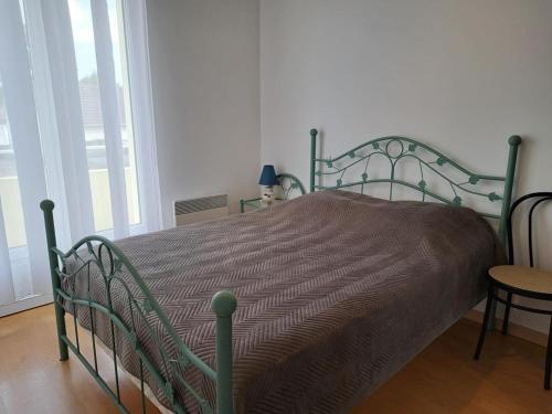 - un lit vert dans une chambre avec fenêtre dans l'établissement Appartement idéal quartier des Demoiselles : Plage, commerces, parking privé - FR-1-323-476, à Saint-Jean-de-Monts