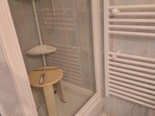 une petite douche avec un tabouret en bois dans un coin dans l'établissement Appartement idéal quartier des Demoiselles : Plage, commerces, parking privé - FR-1-323-476, à Saint-Jean-de-Monts