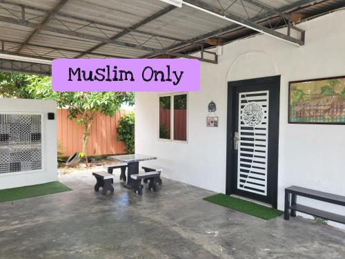 a patio with benches and a sign that reads muslin only at Homestay Kasih Tok Ayah Sg Petani in Sungai Petani