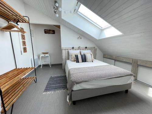 - une chambre avec un grand lit et une lucarne dans l'établissement Duplex lumineux à St-Brevin, proche plage et commerces, parking fermé, 2/3 pers - FR-1-364-151, à Saint-Brévin-les-Pins