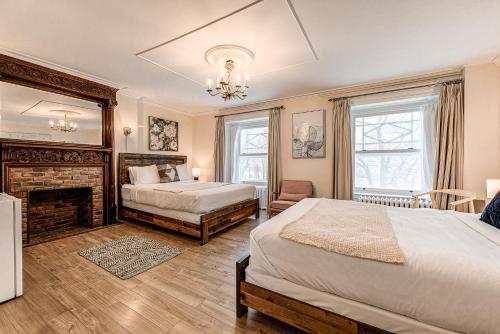 a bedroom with two beds and a fireplace at North House - Auberge La Chouette Hôtel Automatisé in Quebec City