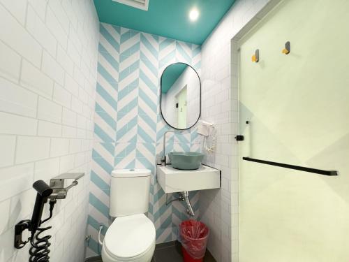 a bathroom with a white toilet and a mirror at Apple 1 Hotel Gurney in George Town