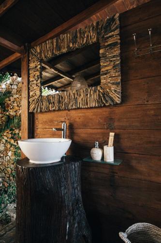 a bathroom with a sink on a tree stump at Villa Ellya Areguling, for 8-10 Pax in Kuta Lombok