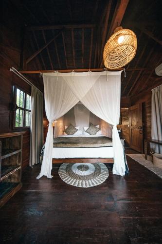 a bedroom with a bed with a canopy at Villa Ellya Areguling, for 8-10 Pax in Kuta Lombok