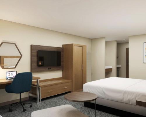 a hotel room with a bed and a desk and a television at Holiday Inn Express Redding North by IHG in Redding