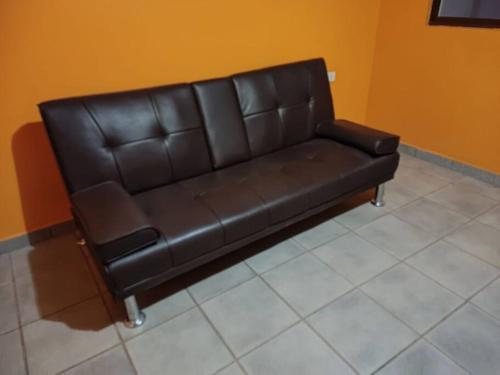 um sofá de couro preto sentado num quarto em Departamento entrada privada em San Pedro de Atacama