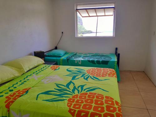 - une chambre avec 2 lits et une fenêtre dans l'établissement Maupiti Dreams, à Te-Fare-Arii