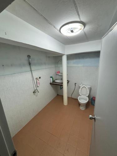 a bathroom with a toilet and a sink and a light at Baan Ja Da in Ban Nai Khlong