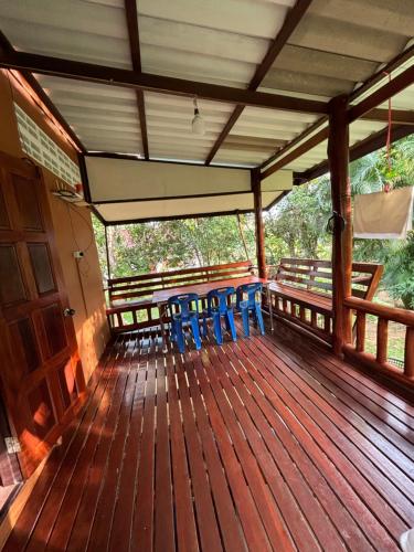 a deck of a house with blue chairs on it at Baan Ja Da in Ban Nai Khlong