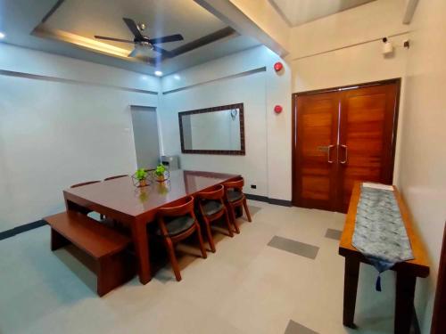 ein Esszimmer mit einem Tisch und Stühlen sowie einem Deckenventilator in der Unterkunft SANDS Hotel Nasugbu in Nasugbu