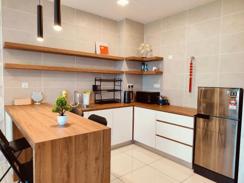 a kitchen with a wooden counter top and a refrigerator at Onsen Studio @ Lost World of Tambun in Tambun