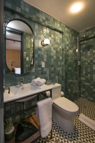 a bathroom with a sink and a toilet and a mirror at Motto By Hilton Cusco in Cusco