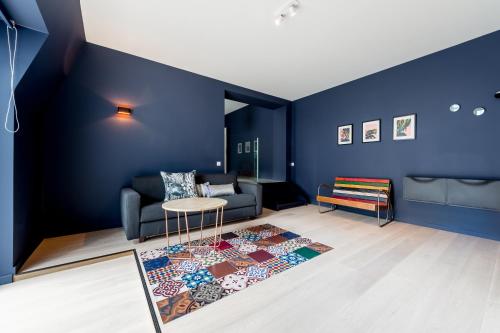 a living room with blue walls and a couch and a rug at Smartflats Design - Cathédrale in Liège