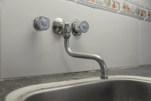 a kitchen sink with a faucet on a wall at Fenix Apart in Concepción del Uruguay