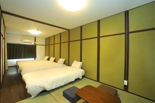 Yagara Terrace House D في أوساكا: غرفة فندقية بسريرين وطاولة