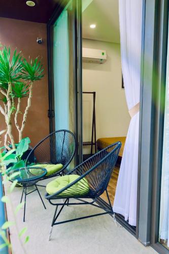 two chairs and a plant in a room at Boom Casa Homestay in Hue