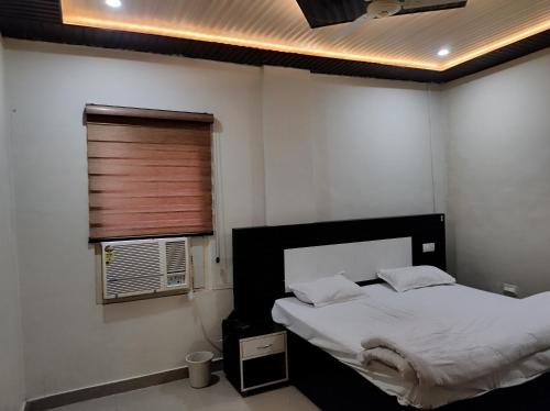 a bedroom with a bed and a window at Arvind Conference Halls in Jhānsi