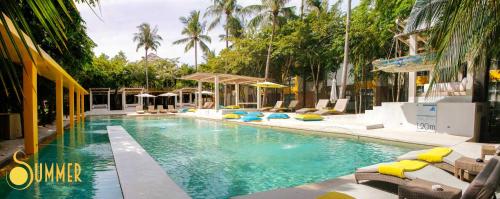 einen Pool mit Liegestühlen und Palmen in der Unterkunft Summer Luxury Beach Resort & Spa in Baan Tai