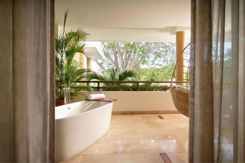 a bathroom with a tub and some plants at The Westin Reserva Conchal, an All-Inclusive Golf Resort & Spa in Playa Conchal