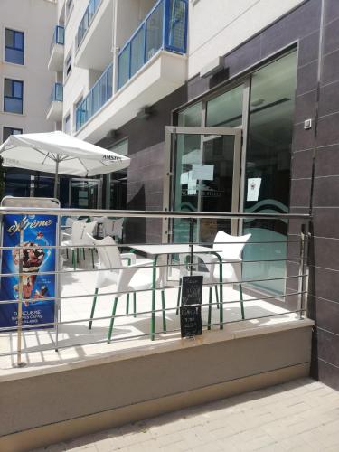 a table and chairs on a balcony with an umbrella at Apartamento confortable en la bahia de Alicante in Alicante