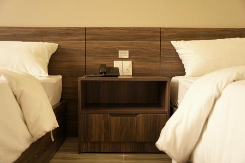 a hotel room with two beds and a phone on a night stand at Tuyet Suong Hotel in Quang Ngai