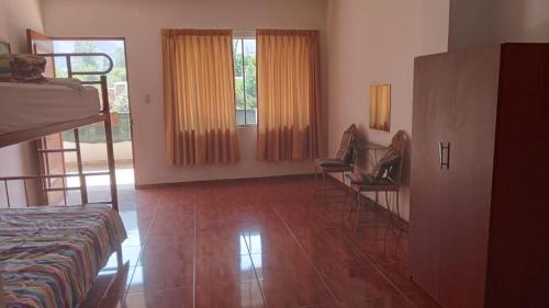 Zimmer mit einem Bett und zwei Stühlen in der Unterkunft CASA DE CAMPO COCACHACRA LODGE in Cocachacra
