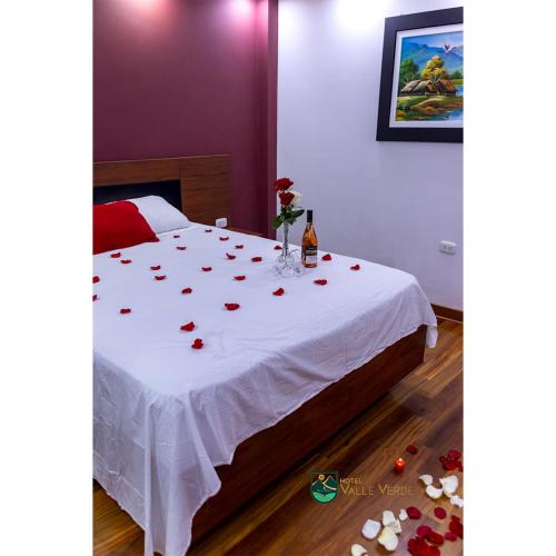 Un dormitorio con una mesa con rosas. en Hotel Valle Verde, en Cajamarca