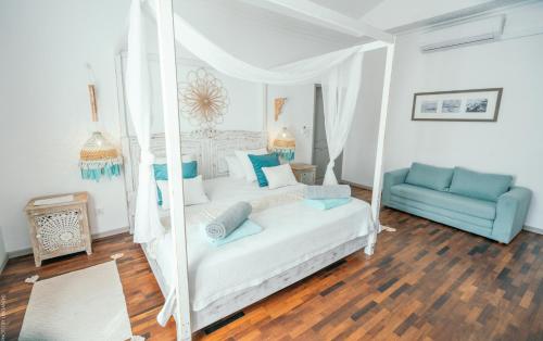 a bedroom with a swinging bed and a blue couch at Au Temps D'antan- Ile Rodrigues in Rodrigues Island
