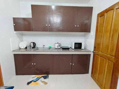 a small kitchen with a sink and a microwave at JADEN Guesthouse in Davao City