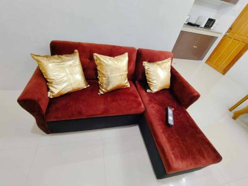 a red couch with gold pillows in a living room at JADEN Guesthouse in Davao City