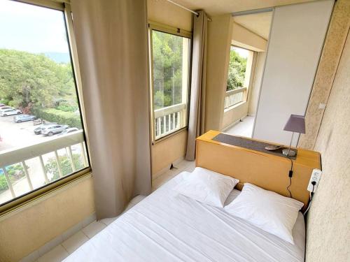 une chambre avec un lit et deux grandes fenêtres dans l'établissement Appartement T2 + Coin Nuit, Parking, Piscine/Tennis, à 200m Plages/Commerces - FR-1-316-323, à Six-Fours-les-Plages