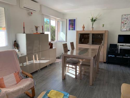 un salon avec une table et une salle à manger dans l'établissement APPARTEMENT 6 PERS CLIMATISÉ - CENTRE VILLE À 15 MIN DE LA MER - 75M2 - 3 CHAMBRES - TERRASSE -CALME - PARKING, au Lavandou