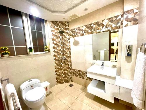 a bathroom with a toilet and a sink at National Luxury Apartments DHA - 3 BedRoom opposite Airport in Lahore