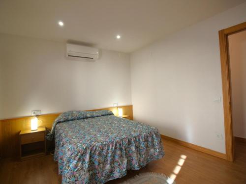 ein Schlafzimmer mit einem Bett und zwei Nachttischen mit Beleuchtung in der Unterkunft Apartamento Vilamaniscle, 3 dormitorios, 6 personas - ES-228-169 in Vilamaniscle