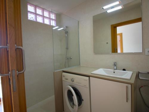 ein Badezimmer mit einer Waschmaschine und einem Waschbecken in der Unterkunft Apartamento Vilamaniscle, 3 dormitorios, 6 personas - ES-228-169 in Vilamaniscle