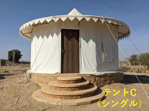 a small tent with stairs leading to a door at Sonal Desert Camp Jaisalmer in Kūri