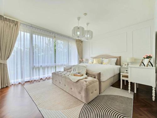a bedroom with a bed and a couch and a desk at Baan Sansaran Excellent apartment on the beach with a large territory and swimming pools. in Hua Hin
