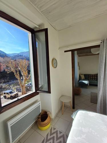 une chambre avec une fenêtre avec vue sur une ville dans l'établissement Riverside apartment, à Sospel