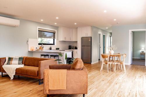ein Wohnzimmer mit einem Sofa und einer Küche in der Unterkunft Lottie's - Absolute Convenience in Bicheno