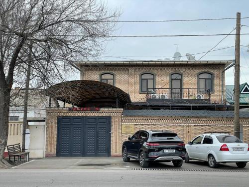 two cars parked in front of a building with a garage at Tashkent hotel Parvoz in Tashkent