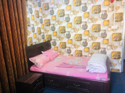 a small bedroom with a pink bed and a wall at Eleven Eleven 11:11 in Burhānilkantha