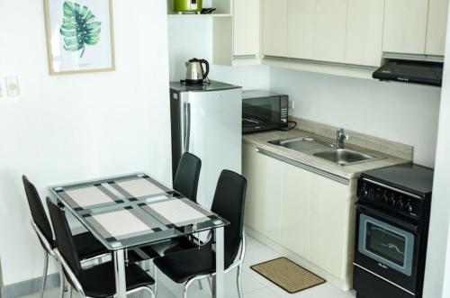 a small kitchen with a table and a sink at KL Tower Makati Apartments by PH Staycation in Manila