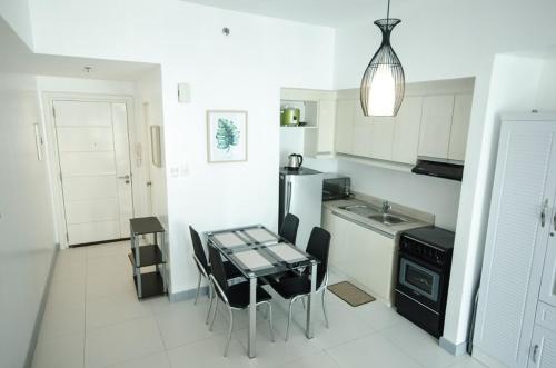 a kitchen with a table and chairs and a sink at KL Tower Makati Apartments by PH Staycation in Manila