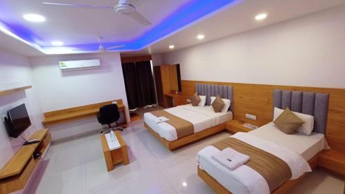 pokój hotelowy z 2 łóżkami i telewizorem w obiekcie HOTEL GREEEN LEAF w mieście Anand