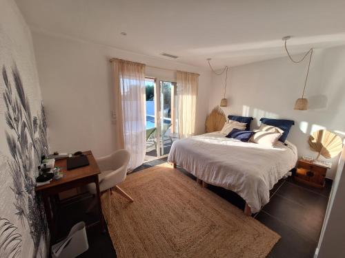 une chambre avec un lit, un bureau et une fenêtre dans l'établissement Villa_palms_mimizan_plage jolie villa 12 personnes, piscine chauffée et plage à pied, à Mimizan